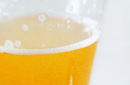 Macro shot of a foaming cold beer ready to drinkの写真素材