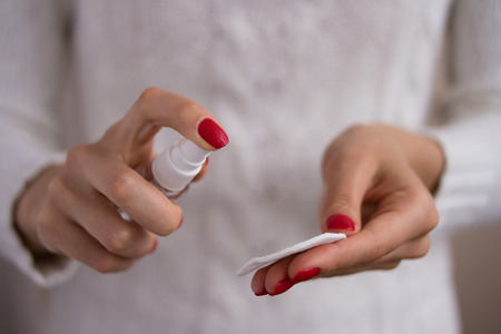 female hands used spray on a white backgroundの写真素材