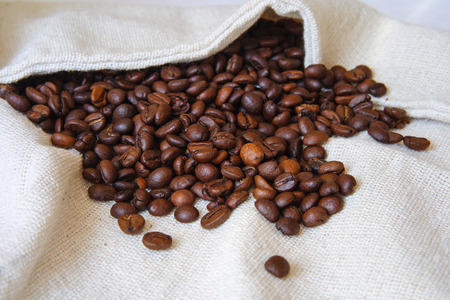 roasted coffee beans on a white bagの写真素材