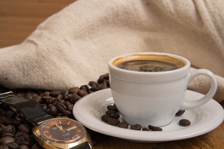 coffee in white cup and old watchesの写真素材