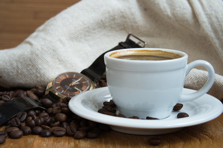 coffee in white cup and old watchesの写真素材
