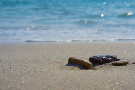 sea pebbles on coastal sand in the sun
