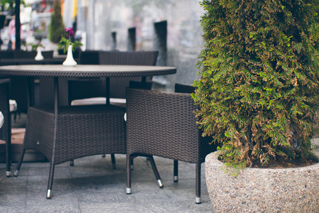 Empty street cafe. Tables and chairs are standing on the sidewalk in the summer in the city.の写真素材