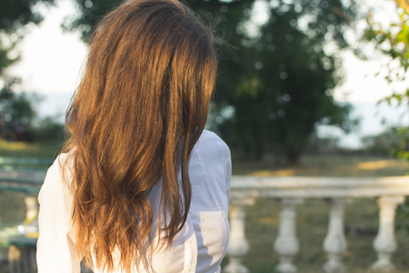 Young slender red-haired woman walking in the park sunny summer day. Outdoor activities close-up.の写真素材