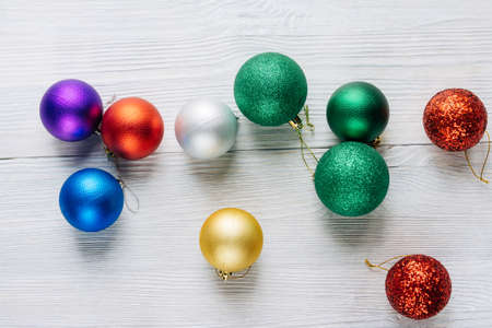 Colored Christmas decorations scattered on a white wooden table. Top view.の写真素材