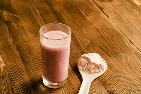 Protein shake in a glass on a wooden tableの写真素材