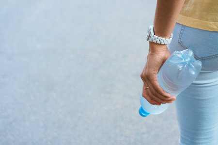 Female hand holding a plastic water bottleの写真素材