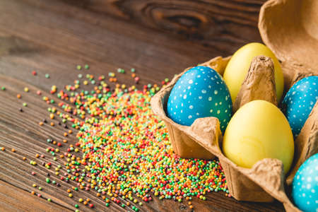 Easter decoration of colored eggs on a wooden tableの写真素材