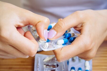 Female hands take out the capsule pill from the blisterの写真素材