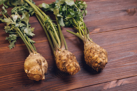 Celery with roots and leaves on wooden table, top viewの写真素材