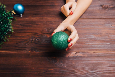 Green Christmas ball in a female hand with red nail polishの写真素材