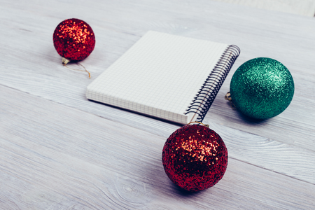 Close-up of notebook and Christmas balls on the tableの写真素材