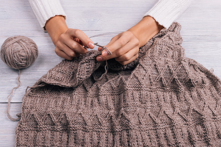 Close-up of female hands knitting wool sweaterの写真素材