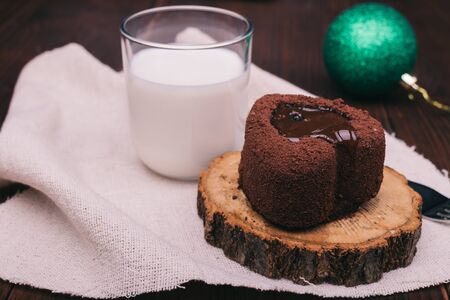 Close-up of chocolate cake, glass of milk and Christmas ball on a wooden tableの写真素材