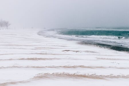 View of the beach in the winter during a snowfallの写真素材