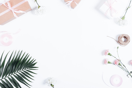 Festive arrangement: boxes with gifts, ribbons and flowers on white table, top viewの写真素材