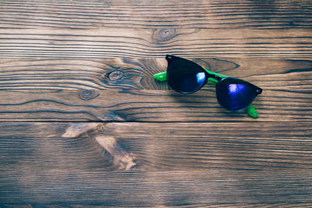 Sunglasses lying on a wooden table top view, copy spaceの写真素材
