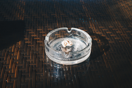 Glass ashtray with chewing gum on a table in a cafe, close-upの写真素材