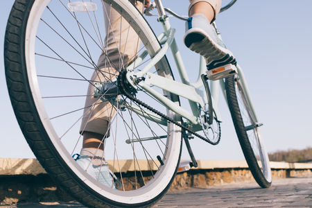 Blue vintage bicycle with white wheels on a sunny summer evening, back view, low angle shootingの写真素材