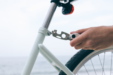 Female hand holds the tool to fix bike, close-upの写真素材