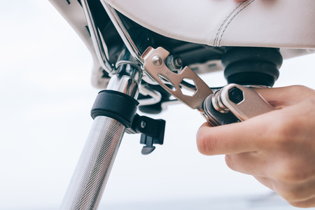 Female hand holds a tool for repairing a bicycle, close-up