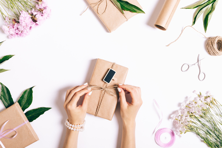 Women's hands are packaged gifts and make decorations for the holiday, top viewの写真素材
