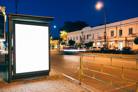 Blank advertising display at a bus stop in the city at nightの写真素材