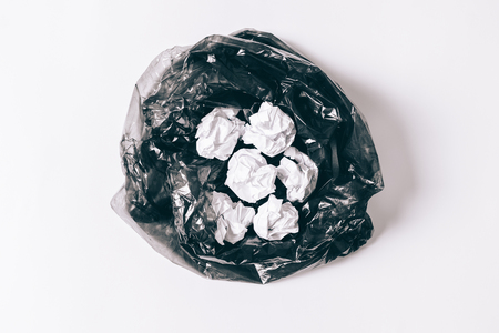 Garbage bag with crumpled pieces of paper on a white background top viewの写真素材