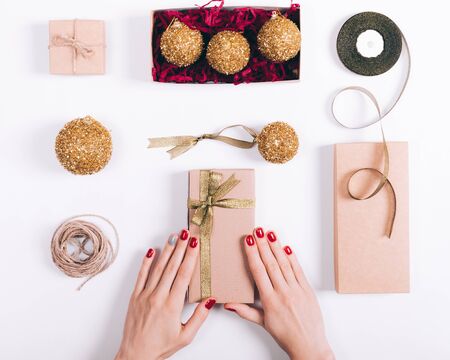 Female hands prepare Christmas decorations on a white table top viewの写真素材