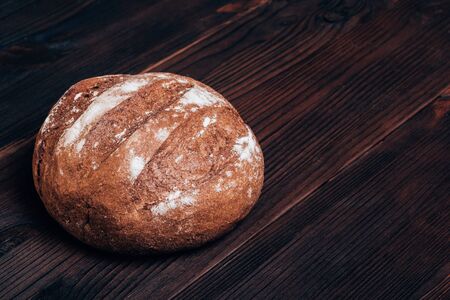 Freshly baked bread on a brown wooden table top view