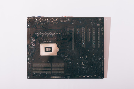Back of the motherboard on a white table close-up, computer details