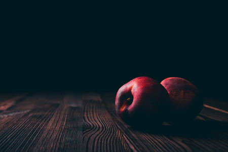 Peaches on a wooden table on a black backgroundの写真素材
