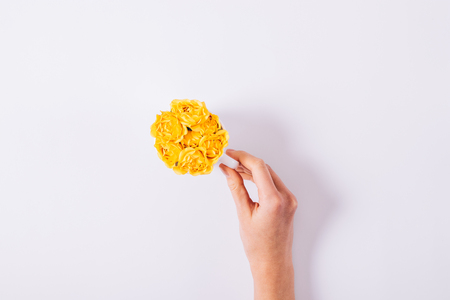 Yellow flowers, female hand and cup on white background top viewの写真素材