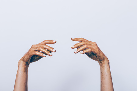 Female hands in golden glitter with white manicure on a gray backgroundの写真素材