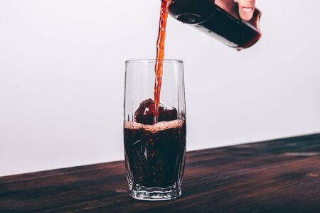 Pomegranate juice is poured into a glass on the tableの写真素材