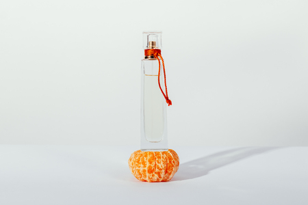 Mandarin and Cologne in a transparent bottle on a white tableの写真素材