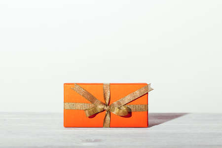 Red gift box with golden ribbon on white background