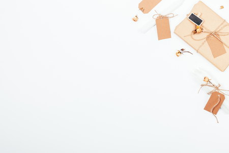 Autumn vintage frame with gift box, candle, cardboard labels and dried rose buds, top view. Romantic flat lay arrangement in beige and brown colours with copy space.の写真素材