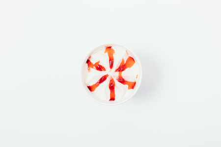 Ice cream with topping red syrup, top view. Flat lay minimal composition of tasty cooling dessert on white background.の写真素材