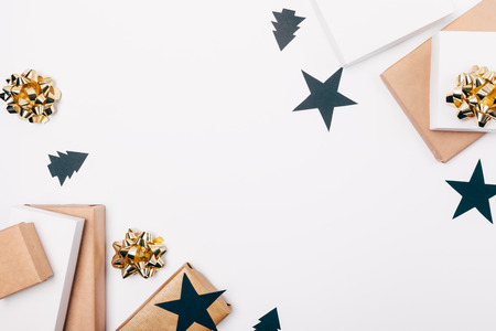 Flat lay frame of Christmas decorations of gift boxes, bows and ribbons of black and gold on white table, top view with blank space in middle.の写真素材