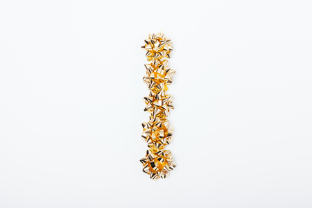 Vertical row of golden bows for packing gifts on white table, top view. Minimal flat layout of holiday decorations, copy space.の写真素材
