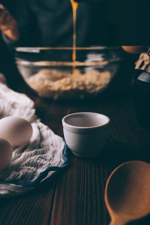 Process of preparing dough for homemade cake on rustic kitchen table. Yolks mixed with sugar are poured into flour and butter.の写真素材
