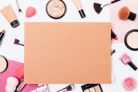 Makeup background of beauty products and tools on table, top view. Flat lay frame of brown paper sheet over women's decorative cosmetics, brushes and accessories.の写真素材
