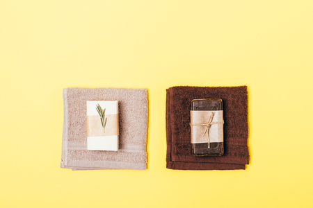 Two hygiene sets of organic soap bars and towels on yellow background, flat lay.の写真素材