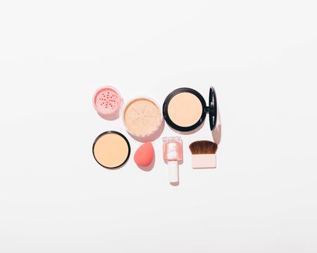 Set of women's cosmetic products on white background with copy space. Top view of blush, powder, brushes and nail polish.の写真素材