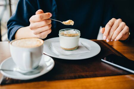 Close-up of a woman in a cafe eating a dessertの写真素材