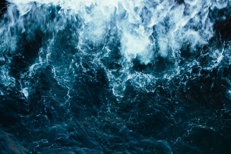 Rough stormy blue ocean waves with white foam, aerial view.の写真素材