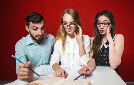 A group of young attractive students have a friendly discussion, surprized reaction, teamwork student conceptの写真素材