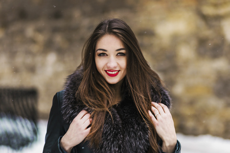 Portrait of beautiful brunette girl having fun in snowy winter timeの写真素材