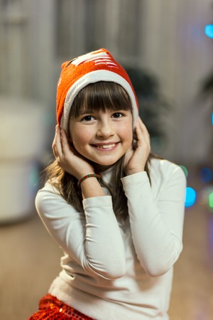 portrait of happy smiling girl wears santa hatの写真素材